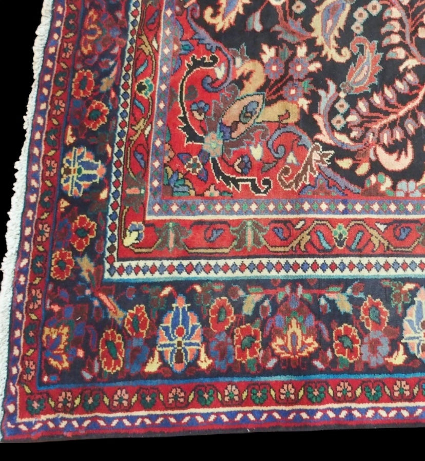 A black floral foliate patterned ground Lilihan rug