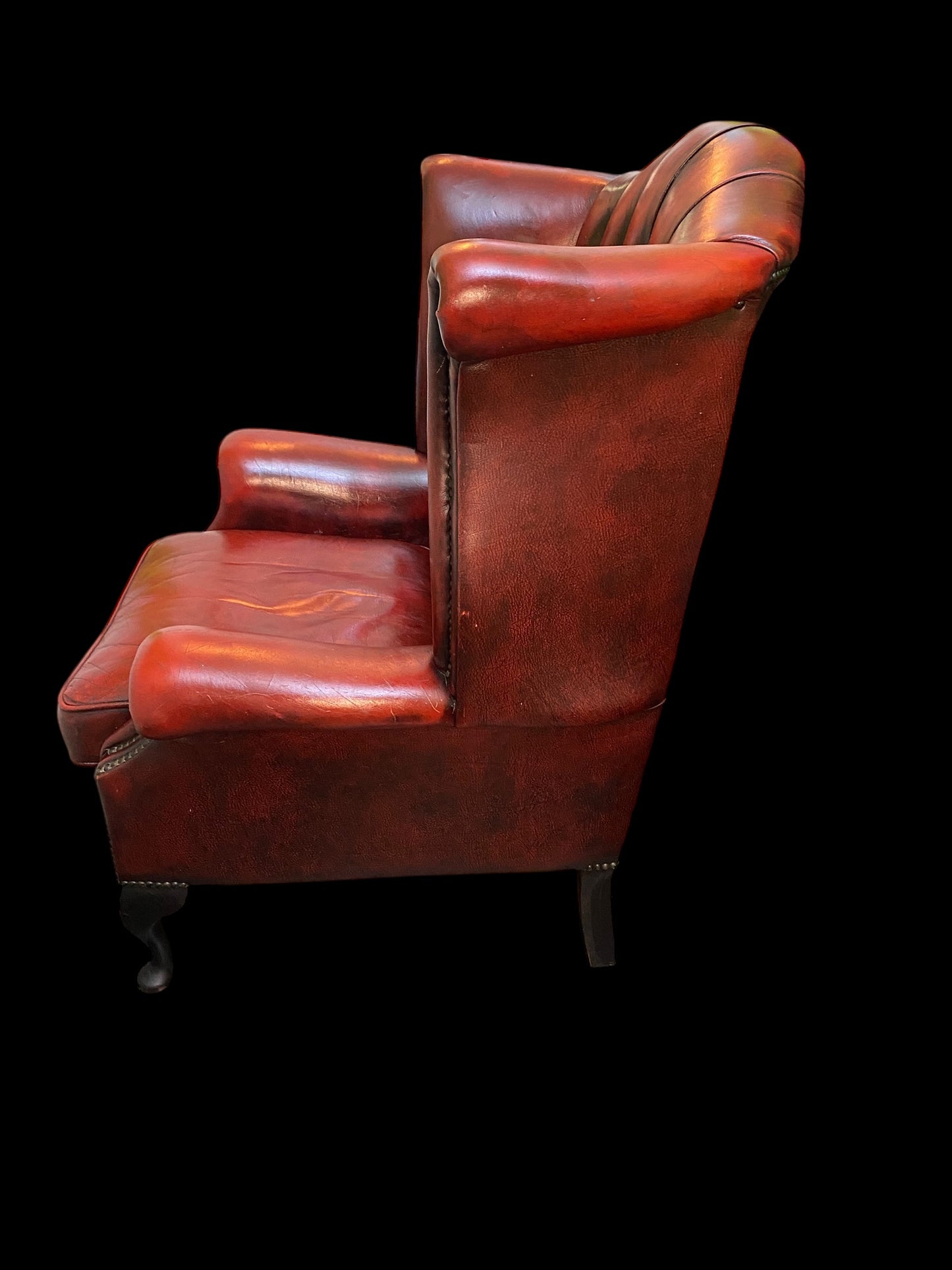 A sumptuous oxblood leather buttoned wingback armchair