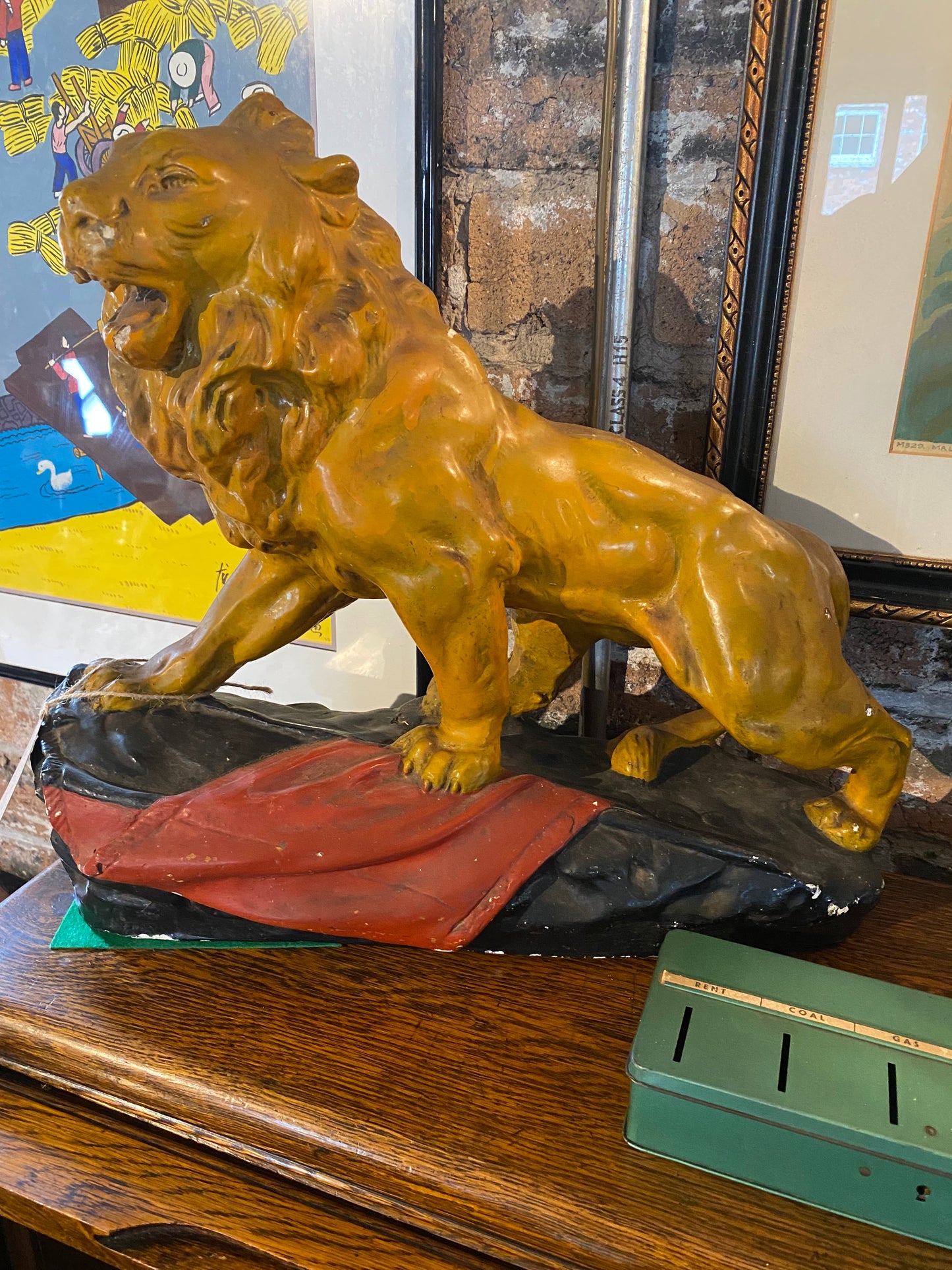 A stunning glazed chalk sculpture of a lion on a plinth