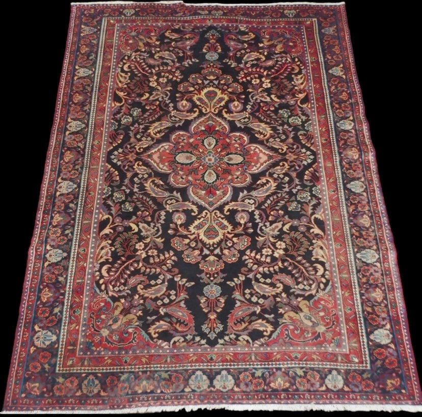 A black floral foliate patterned ground Lilihan rug