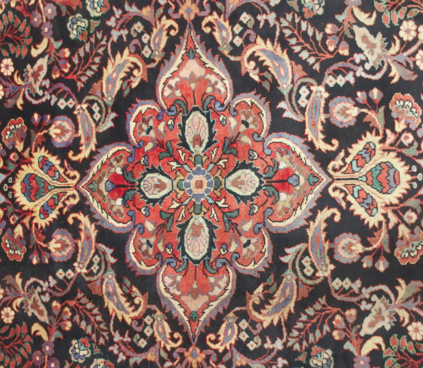 A black floral foliate patterned ground Lilihan rug