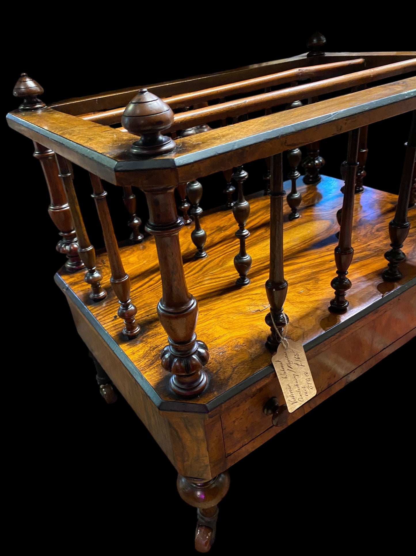 Late Victorian walnut Canterbury on brass casters and single drawer