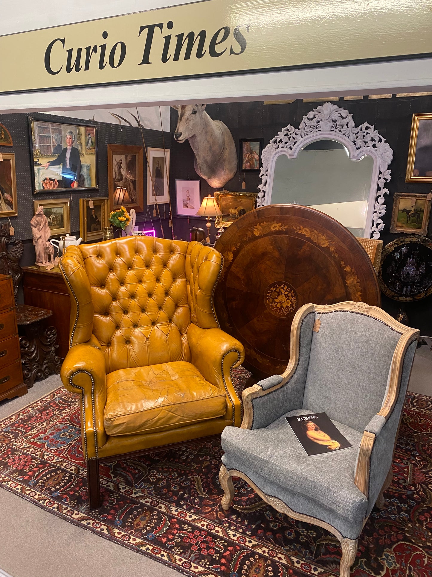 A VERY large, well worn, mustard coloured leather Chesterfield style wingback chair