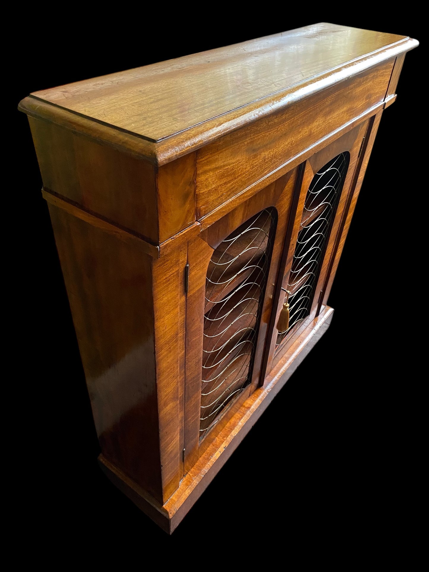 A rich walnut double door bookcase with single frieze drawer over wire mesh doors