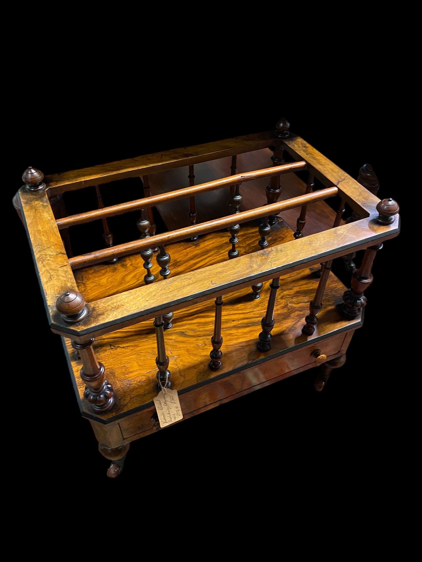 Late Victorian walnut Canterbury on brass casters and single drawer