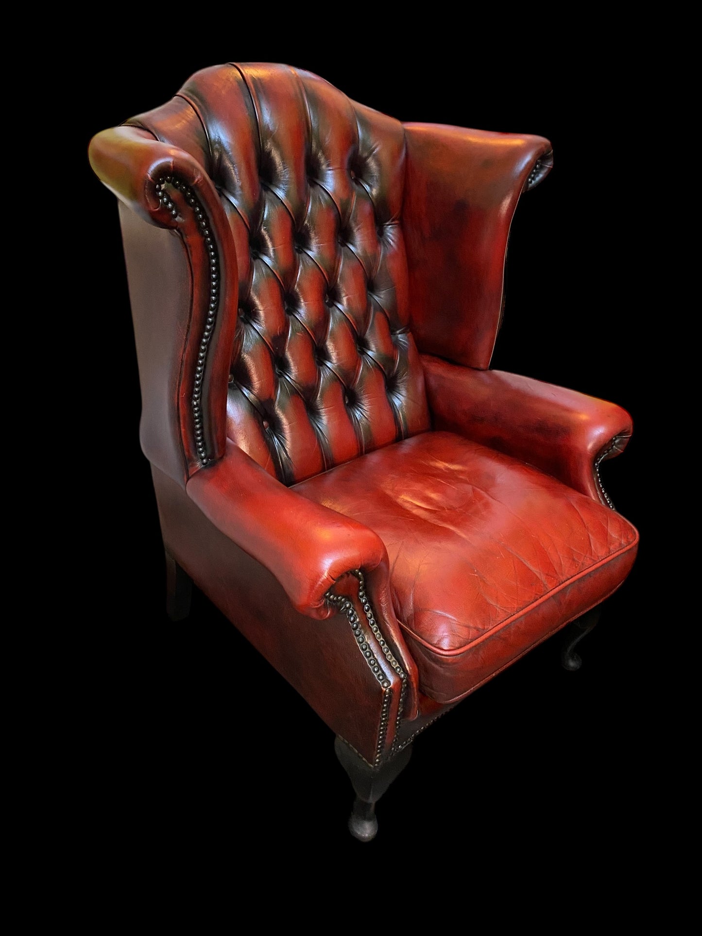 A sumptuous oxblood leather buttoned wingback armchair