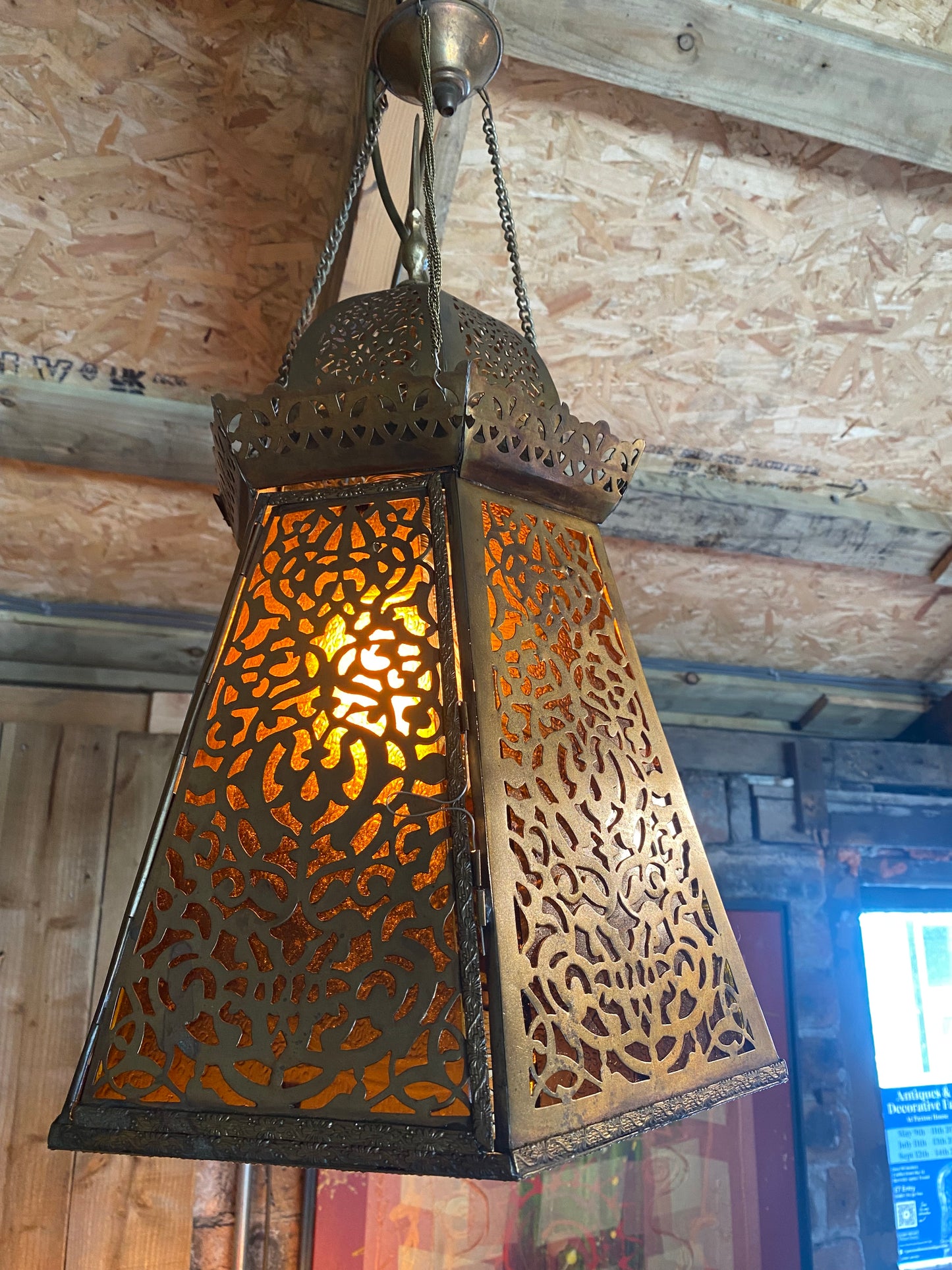 A pair of Moroccan brass lanterns with amber glass insets