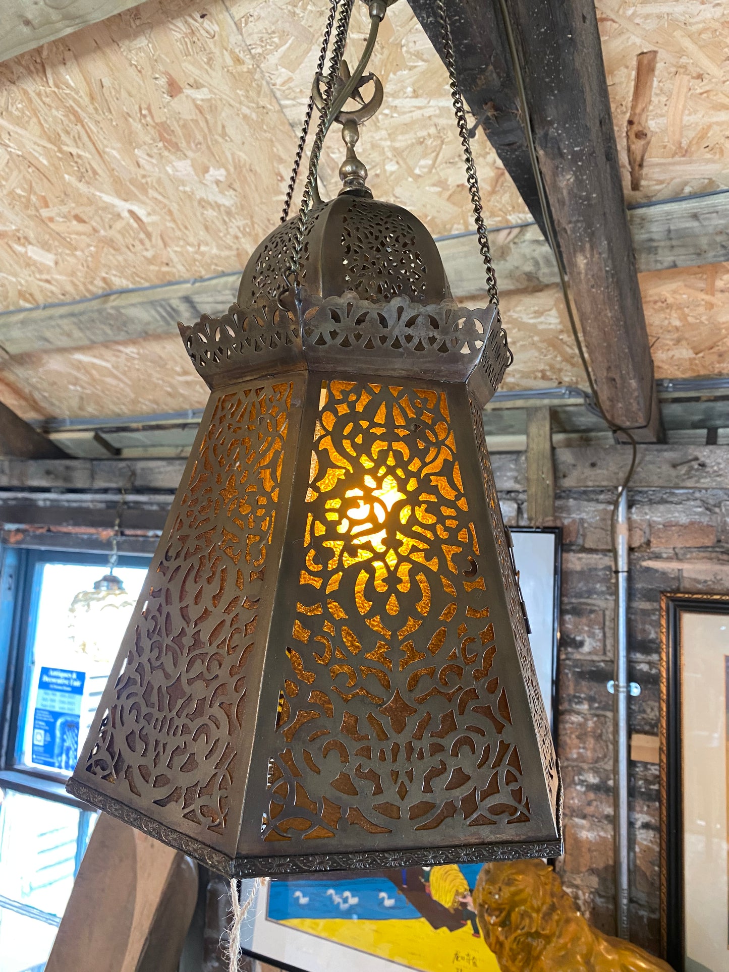 A pair of Moroccan brass lanterns with amber glass insets