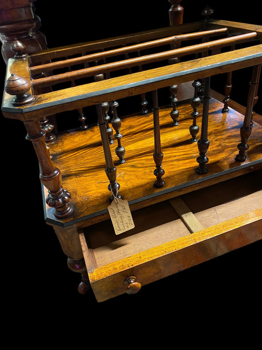 Late Victorian walnut Canterbury on brass casters and single drawer