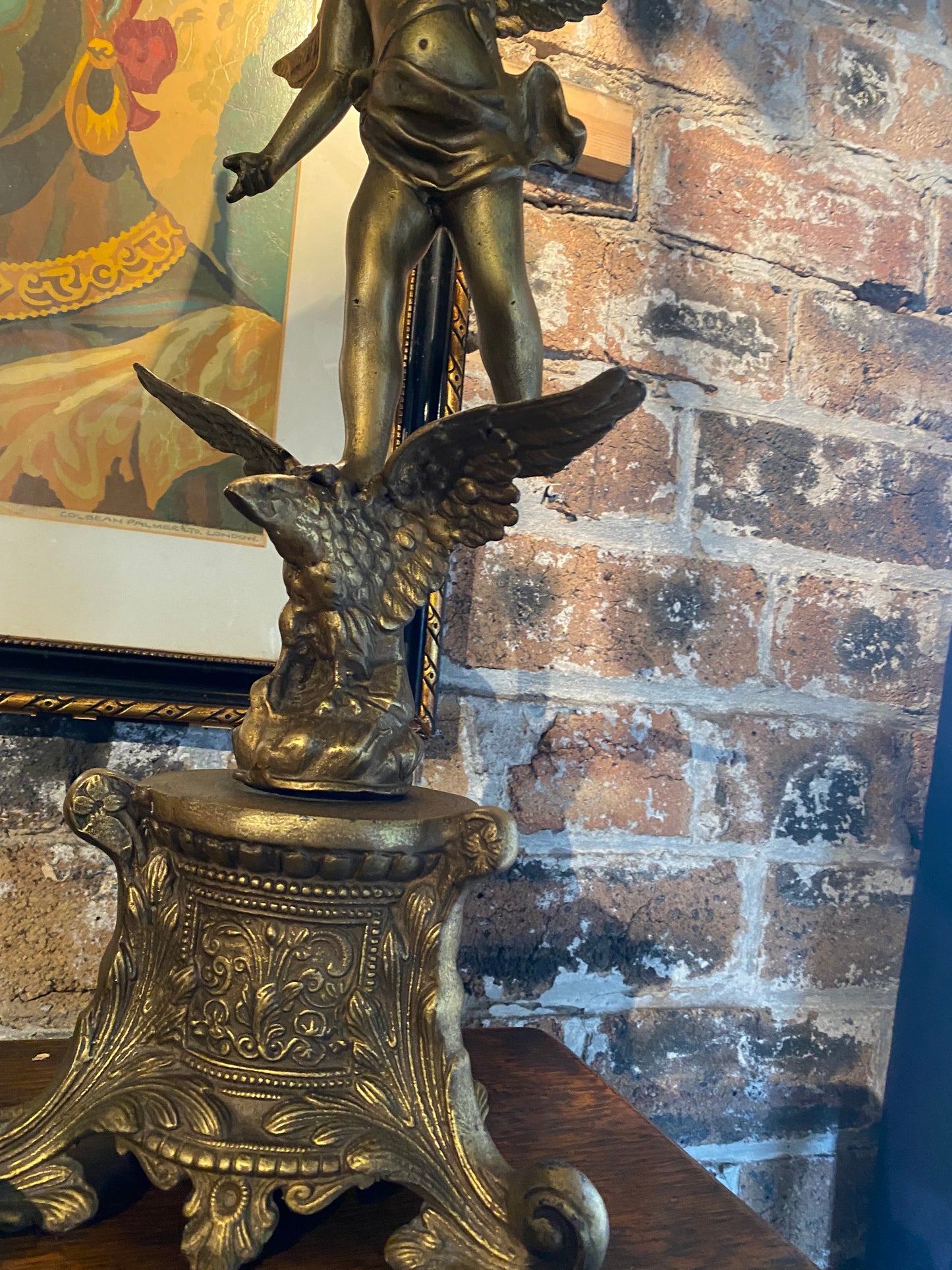 Vintage table lamp in brass with a cherub holding a lantern over an eagle