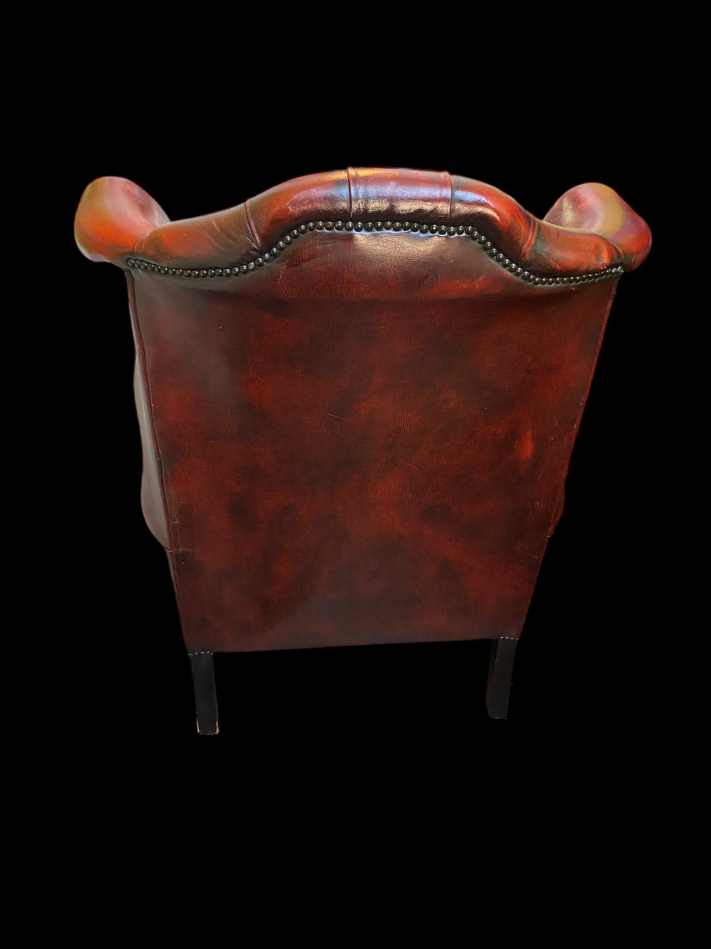 A sumptuous oxblood leather buttoned wingback armchair