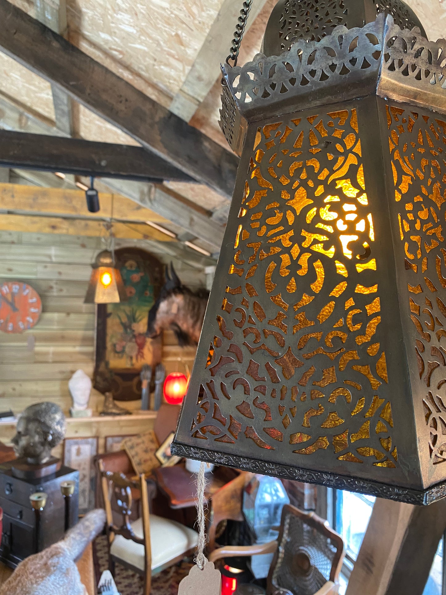 A pair of Moroccan brass lanterns with amber glass insets