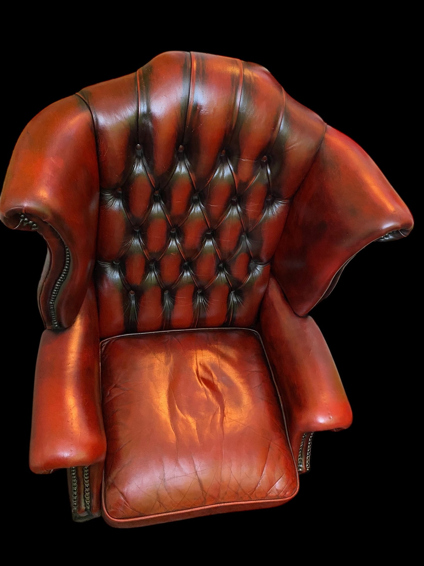 A sumptuous oxblood leather buttoned wingback armchair