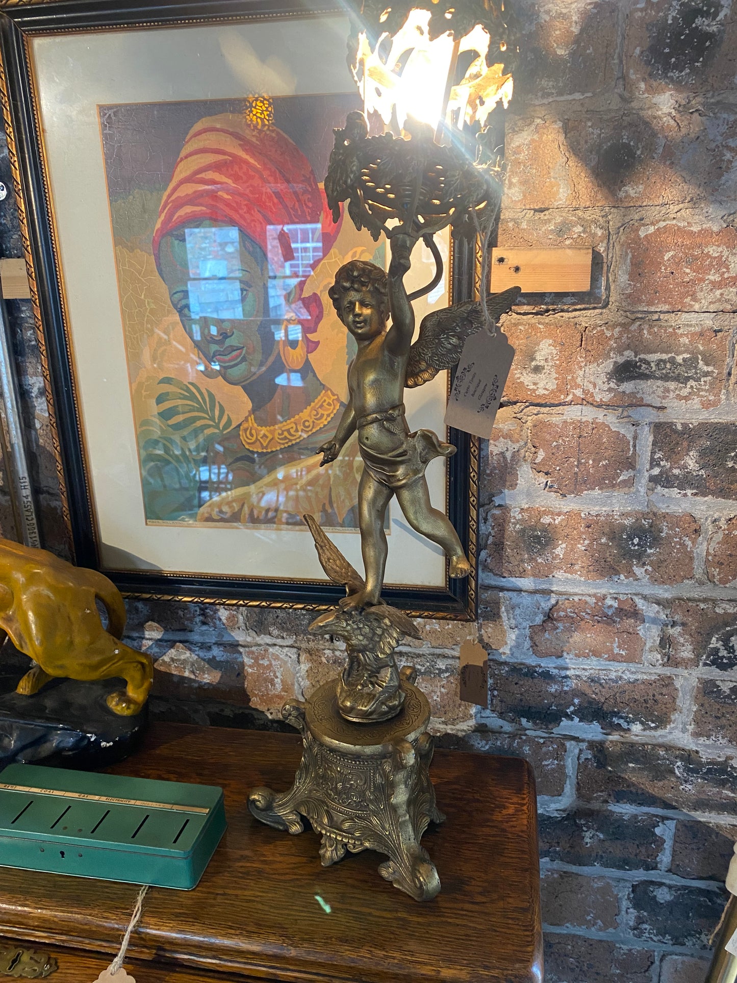 Vintage table lamp in brass with a cherub holding a lantern over an eagle