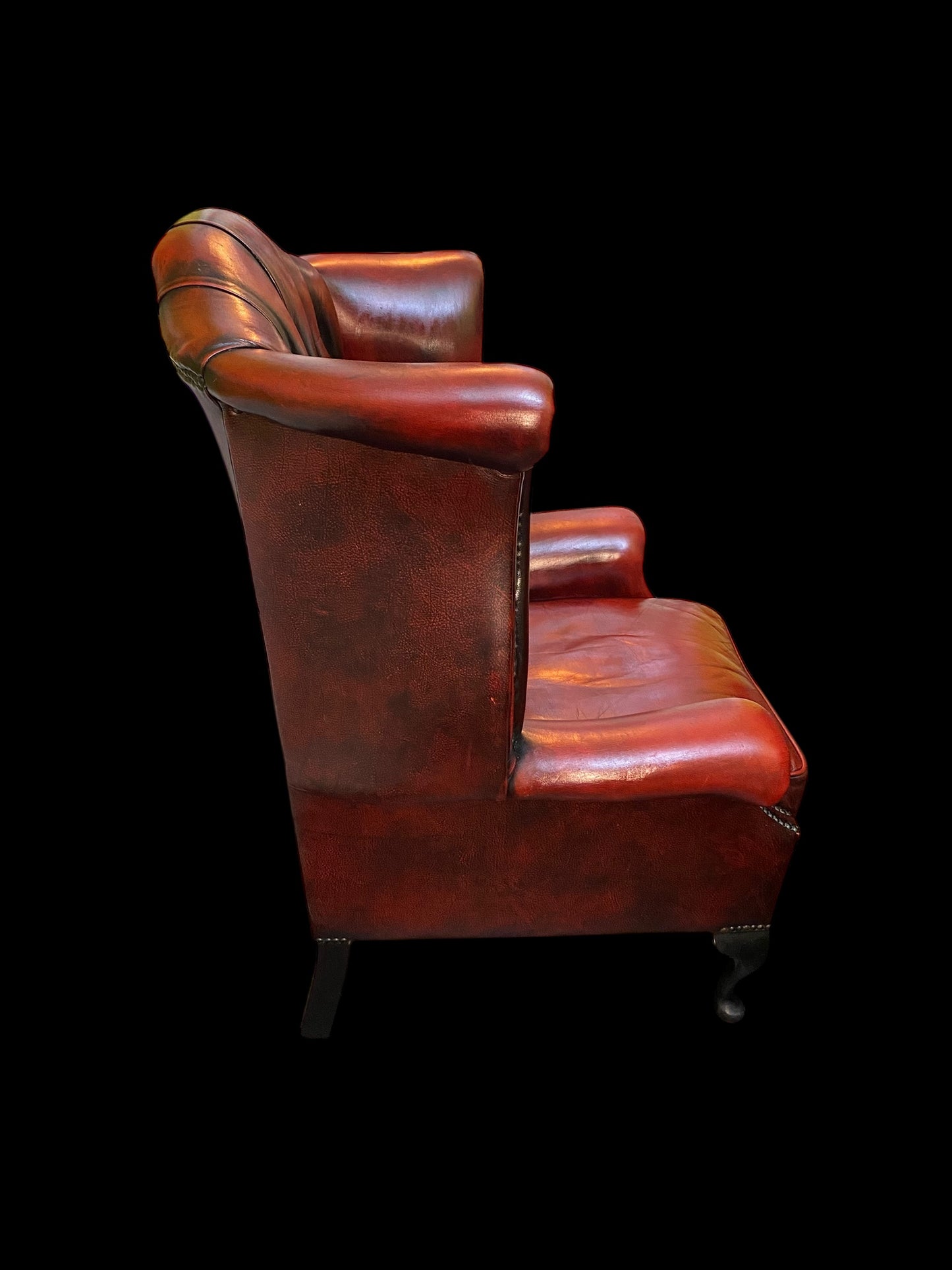 A sumptuous oxblood leather buttoned wingback armchair
