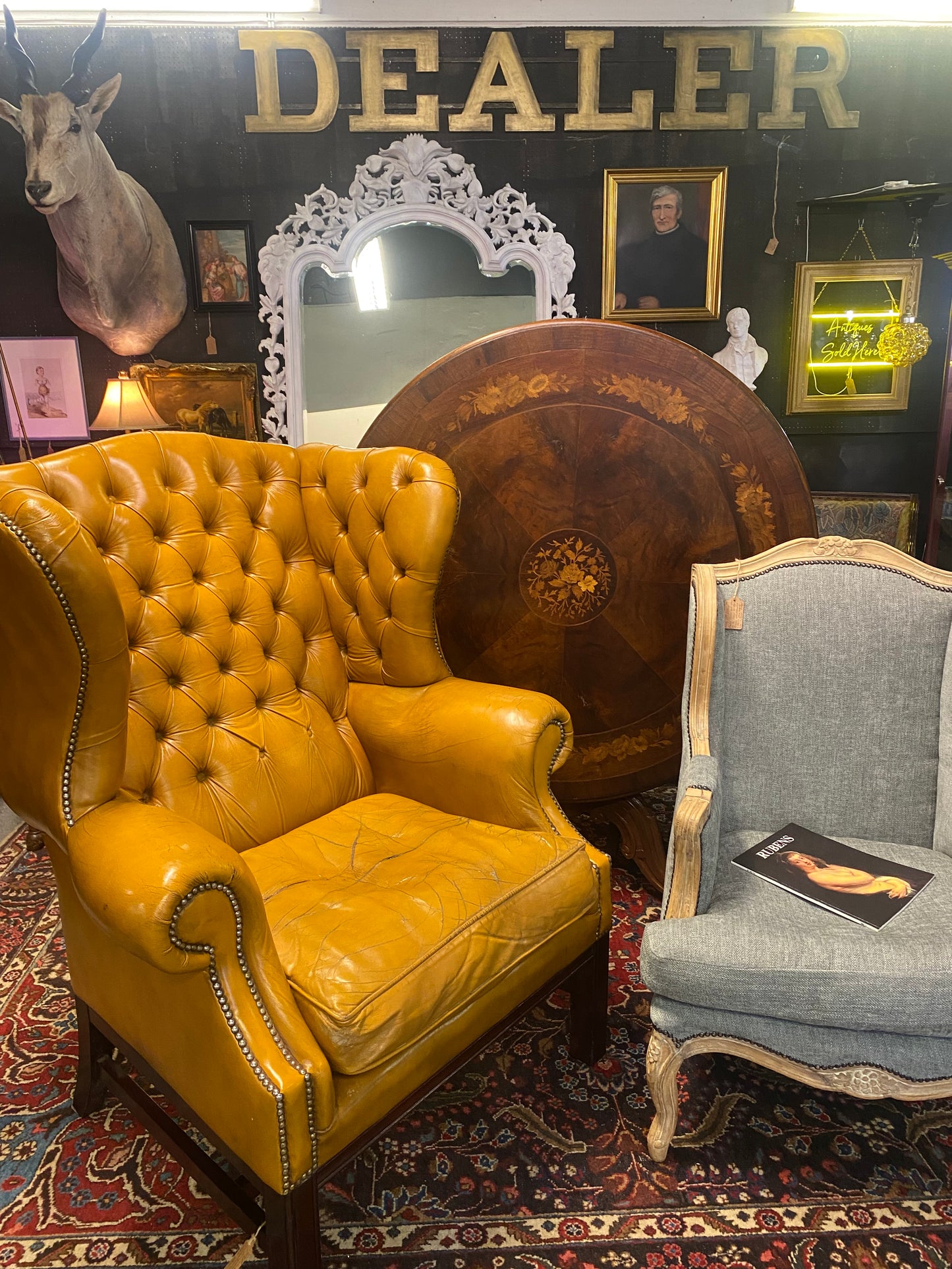 A VERY large, well worn, mustard coloured leather Chesterfield style wingback chair